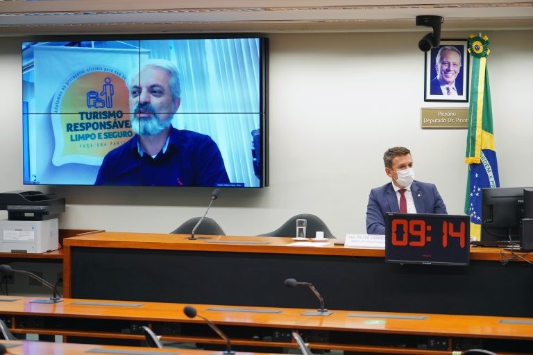 Carreras preside a reunião, no telão o secretário William França - (Foto: Pablo Valadares/Câmara dos Deputados)